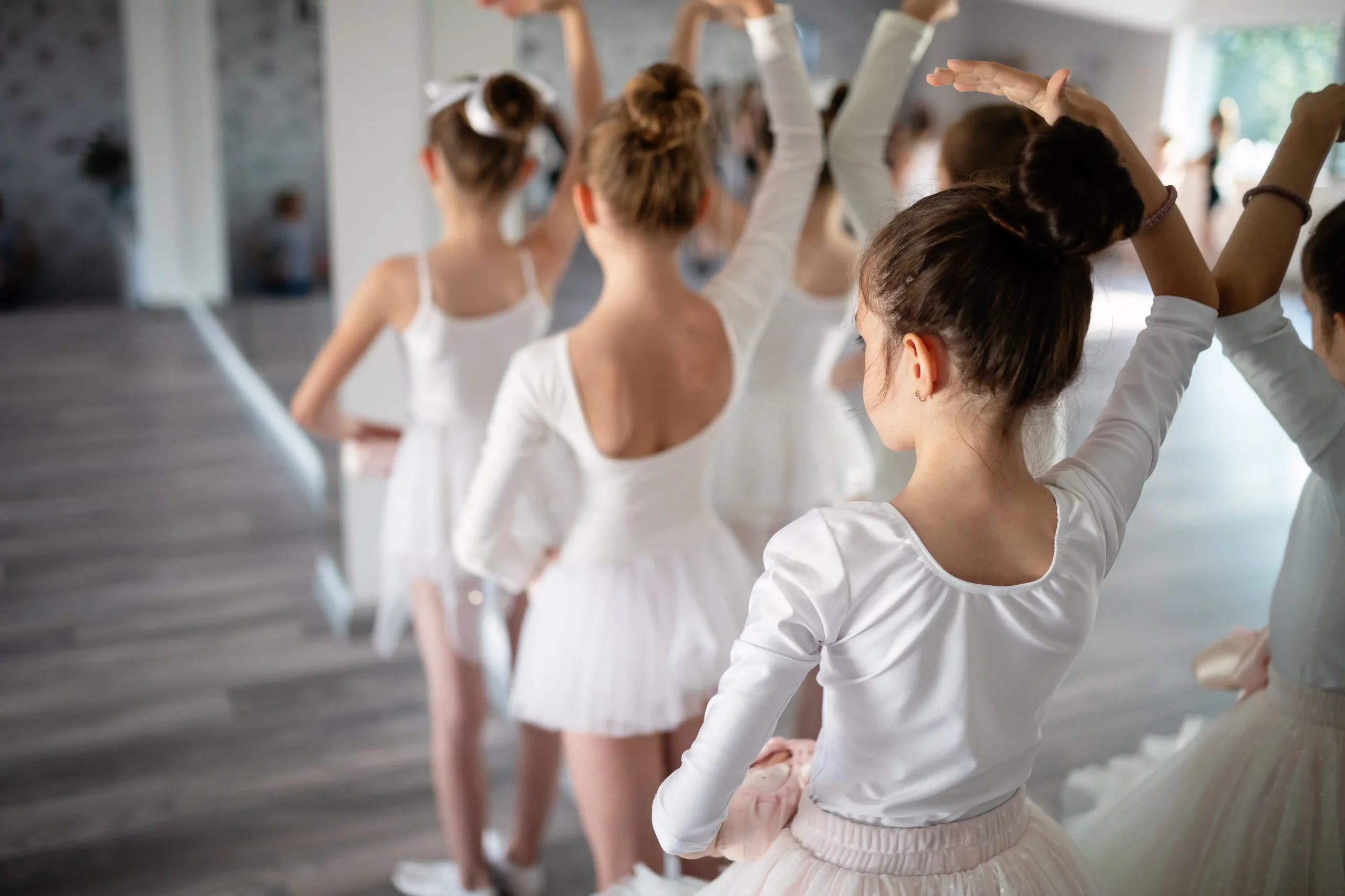 Foto einer Gruppe Mädchen die gemeinsam Ballett tanzen üben.
